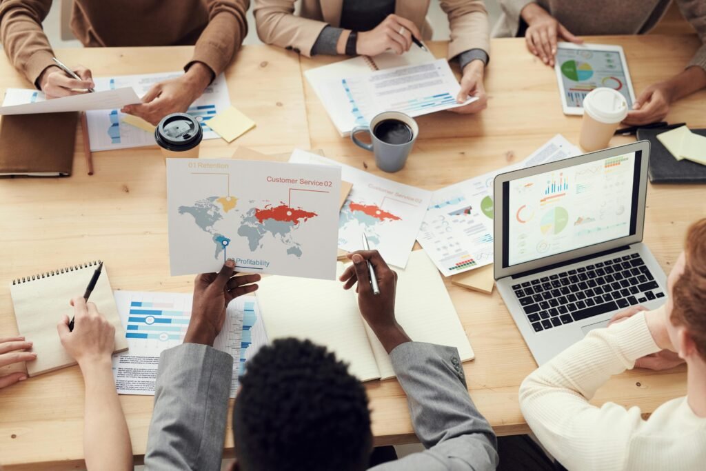 Diverse professionals brainstorming with laptops and charts in a contemporary office setting.